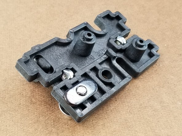 Using the bolt with a washer, put it through the PEEK bracket and side plate bracket and insert a T-Nut (the flat black threaded nut).  Do not tighten this fully. You want it to remain loose.