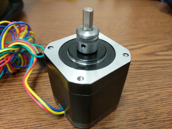 Align the set screw of the hobbed drive roller with the flat of the stepper motor shaft and install the hobbed drive roller on the stepper motor. Use the existing stepper motor for comparison of placement.