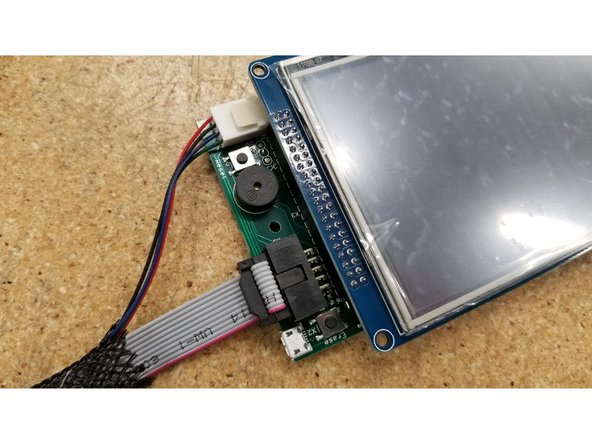 Plug in the two cables as pictured. Make sure the green wire on the molex connector is oriented towards the ribbon cable, and the red wire on the ribbon cable is oriented towards the  &quot;Erase&quot; button.