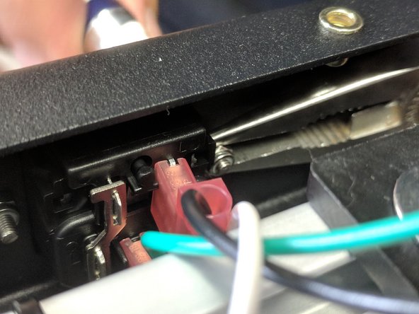 These nuts are hard to get to. It is easiest to hold them with a pair of needle nose pliers, and even better if you have angled needle-nose pliers.