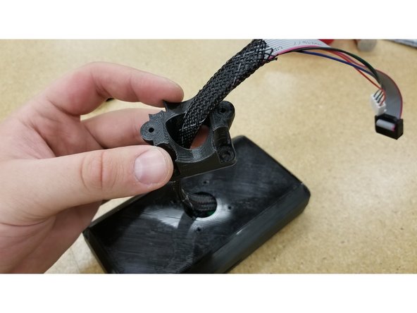 Locate the screen mounting saddle and pass the cables through as shown.