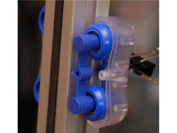 Route the two belt ends through the face of the inner carriage and attach a binder clip to the ends.  This will prevent them from slipping out of the carriage while you're working on it.