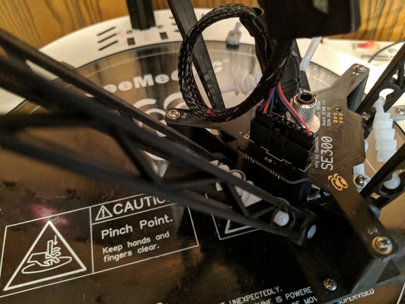 Lift the boot covering the 10 pin connector and unplug the 10 pin connector from the hotend as shown in Pic 1.