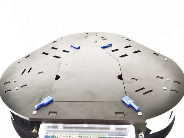 Position the spool holder on the top plate of the machine in the four rectangular cutouts.