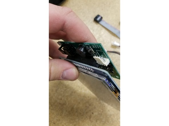 Plug in the two cables as pictured. Make sure the green wire on the molex connector is oriented towards the ribbon cable, and the red wire on the ribbon cable is oriented towards the  &quot;Erase&quot; button.