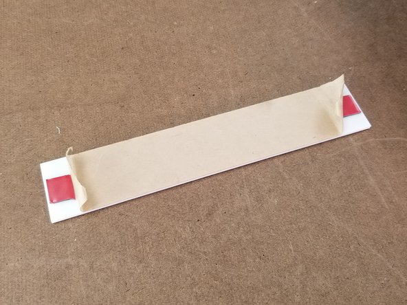 Locate the white acrylic back plate from the frame pack.  This will have double sided tape pre installed on it.