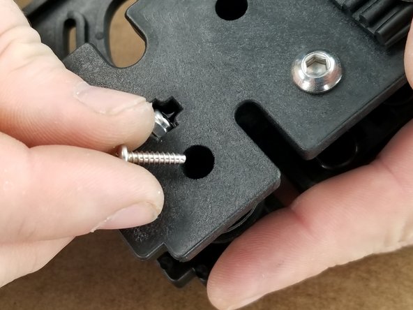 In the 2 holes of the smaller bracket, insert a screw into each hole and tighten the halves together using a standard P1 Phillips screwdriver.