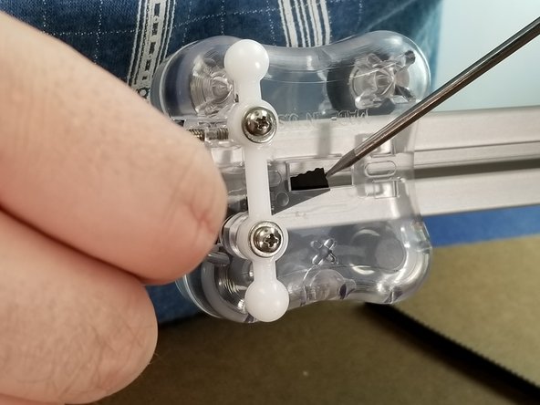 From the belt hanging from the top of the machine, feed the belt behind the carriage top and use a flathead screwdriver or other tool to help feed the belt out the hole in the center of the carriage as shown in Pic 2 and 3.