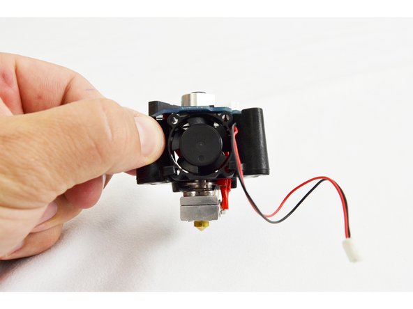 Tilt the fan at a slight angle and slide the it into the fan mount legs of the PCB mount. THE SIDE OF THE FAN WITH THE LABEL SHOULD BE CLOSEST TO THE HOT END HEAT SINK.