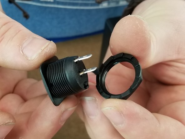 Remove the large nut from the rocker switch to separate them.