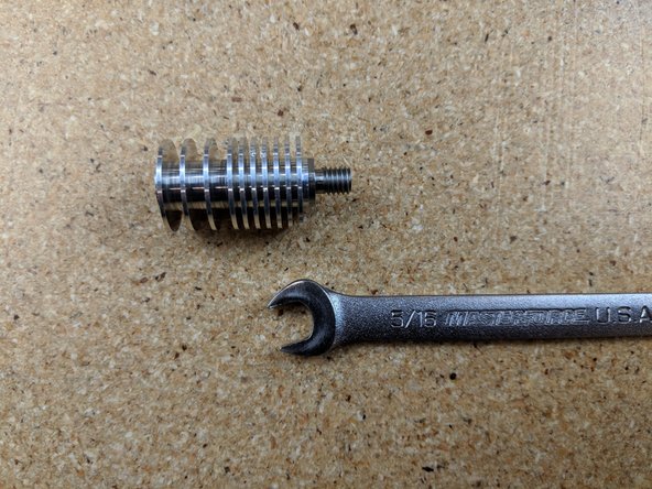 The heat break has 2 flats on it used to tighten it. Use a 5/16 wrench or an adjustable wrench and securely tighten the heat break to the heat sink.