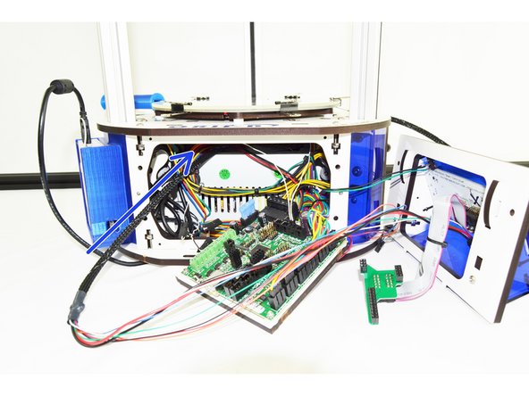 From the front of the printer, insert the new whip (8 pin connector first) through the front of the machine, over the hot end and out the side of the machine with the extruder panel removed.