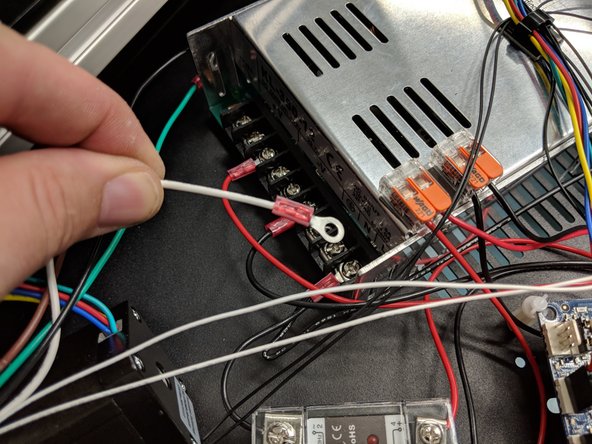 The ground (green) and neutral (white) wires go to their respective locations on the power supply. Unscrew the clamps and reinstall with the ring terminals in place as shown.