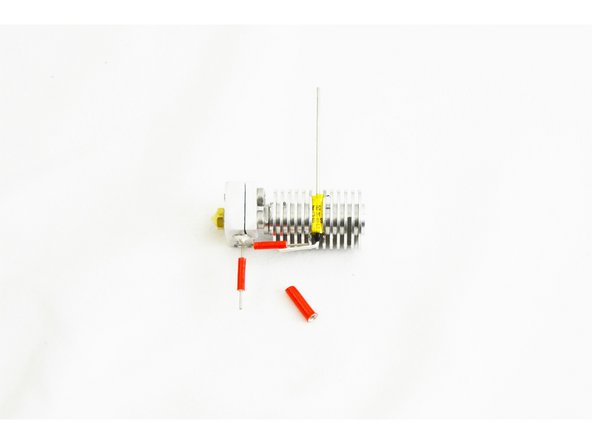 Insert the non-insulated wire ferrule into one of the pieces of red silicone high temp insulation, centering it.