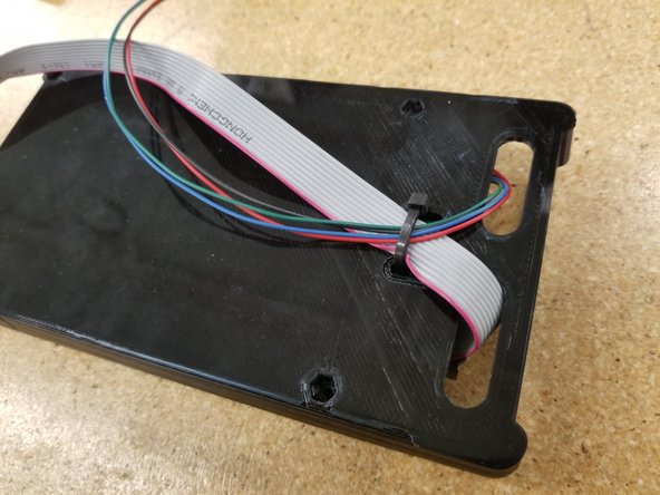 Affix them with a zip tie as shown. You do not need to crank down the zip tie, be more kind to that ribbon cable than the photo shows...