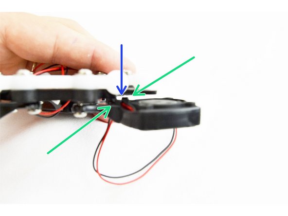 Route the fan leads along the body of the fan and in between the two bosses (indicated with green arrows)