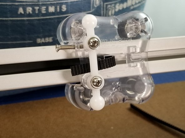 With the belt out the middle of the carraiage, bend the belt up and behind the white ball joints as shown in Pic 1 to hold it in place temporarily.