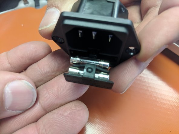 Open the fuse drawer on the IEC connector. Insert the two fuses that were provided into the location. as seen in the image. Close the drawer.