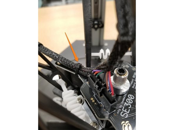 Attach a zip tie to the wires attaching the section of the whip after the 10 pin connector to the hotend board as shown in the photos.