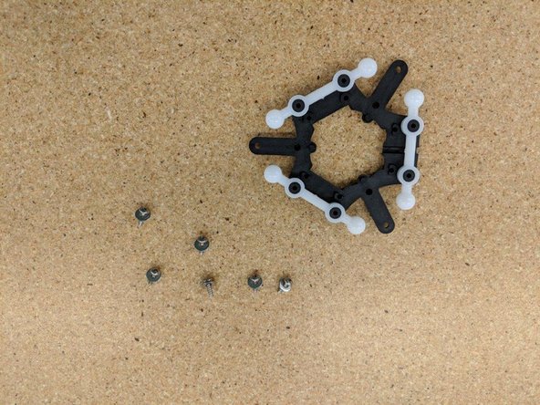 Press each ball arm over the mounting posts on the effector platform.