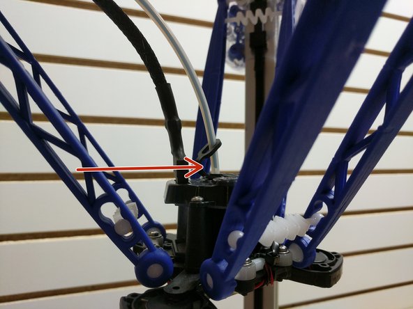 Route the filament through the two guides in the back of the printer.