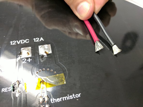 Fan out the exposed strands of wire for the 12awg red and black wires. Solder them to the heated bed in the location indicated ( The - pad and the 2+ pad)