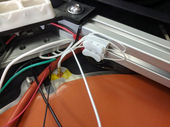 Cut and strip the thermistor wires from the Z tower 1.5 inches beyond the white toggle connector.