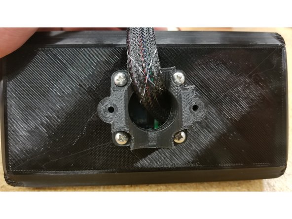 Position the saddle on the enclosure as shown, ensuring the two screw mounting points are parallel to the screen.