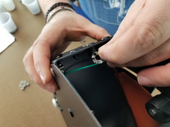 Holding the screw in place, put the spike grounding washer over the screw from the inside of the machine with the spikes facing the sheet metal.