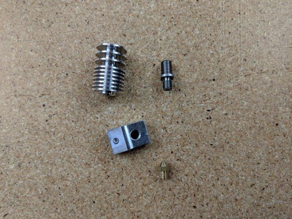 First remove the nozzle (should only be on finger tight when taken from the kit).  Then unscrew the heater block. Finally unscrew the heat break.  You should have 4 seperate pieces.