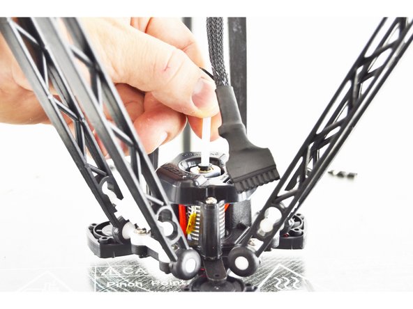 Insert the Bowden (PTFE) Tube into the top of the hot end. Press the tube down until you feel it seat in the bottom of the hot end. Press the hot end effector down so the nozzle is against the glass plate and give the Bowden (PTFE) Tube one more good push to ensure that it is seated fully.