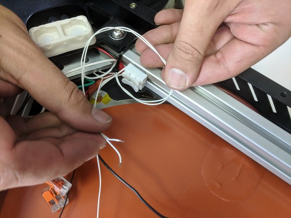 Route the thermistor wires (2 white wires) from the Z tower over the braided wires coming from the aluminum heat spreader (this is the bed thermistor).