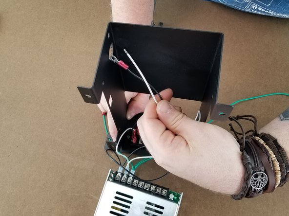 Route the long white and black wire through the round hole in the back of the bracket.