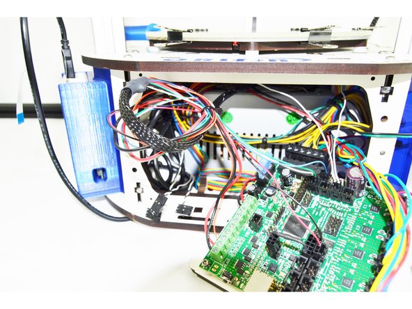 Coil the wire once and add a cable tie to secure it. (Shown in the image with a black circle)