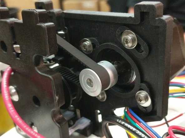 If you've pulled the belt tight when installing the last belt retaining clip, you only need to add a little more tension to the belt. Rotate the stepper motor so it's about 1/4 the way across the screw slot and tighten all four screws. Do this for each stepper motor.