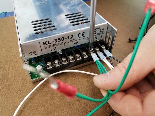 In the third location next to the white wires, you will secure the blue ring terminal with 3 green wires going to it into the screw next to the white wires.