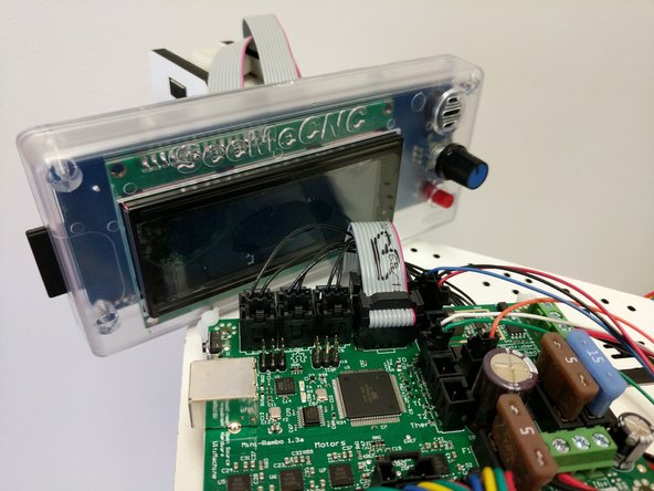 Install the A ribbon cable on the Mini-RAMBo on the 2x5 pin header closest to the edge of the Mini-RAMBo. The red stripe should be closest to the fuses.