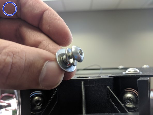 Attach the tower to the upper assembly using 2 each of the provided 1/4-20 x 1" long button head screws, split ring washer, and flat washer, stacked as shown in the image with the blue circle. Fully Tighten.