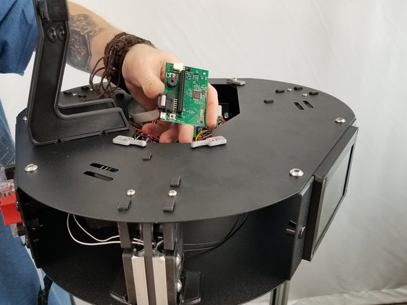 Pass the  control board through one of the openings in the top assembly.