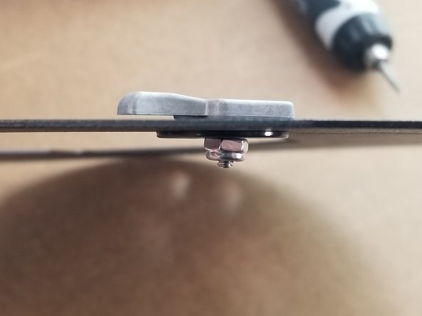 The first picture shows the build clamp in place.  The orientation should be clamp, sheet metal top plate, large plastic washer, then nylon lock nut.