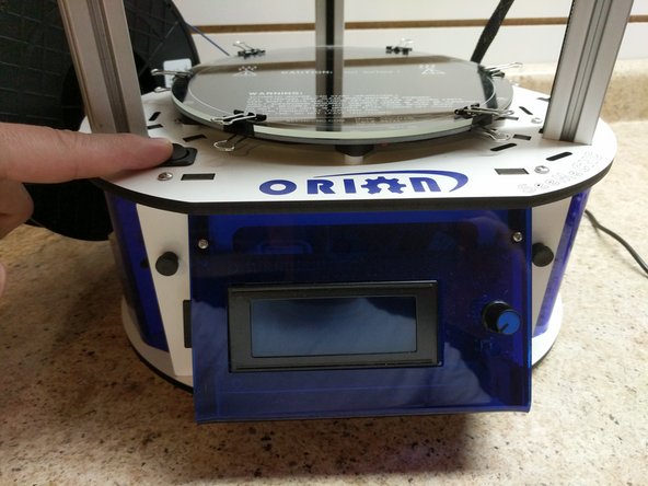 The power switch is located above the LCD screen (note the position in the image). Power the printer on.