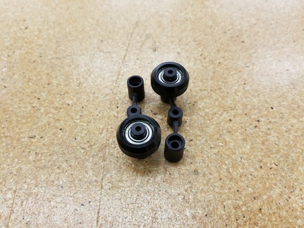 Press the bearings on to the post of either spring arm, as shown in the second photo.