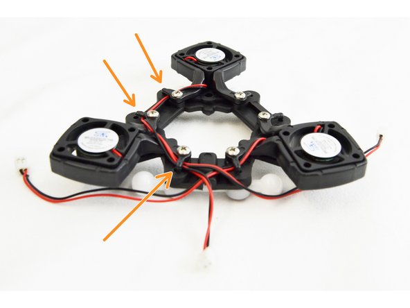 Next you will route the leads of the layer fan farthest from the channel. These fan leads will go under 3 wire management tabs as they pass around the perimeter of the ball joint platform.
