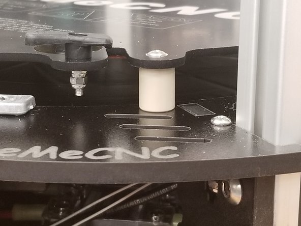 Pass the pan head screws through the mounting holes on the heat spreader, then through the 84612 Bed Mounting Post (PEEK), the melamine frame of the printer, then the 30450 #6 SAE Flat Washer - SS with the three remaining 30164 nylon lock nuts