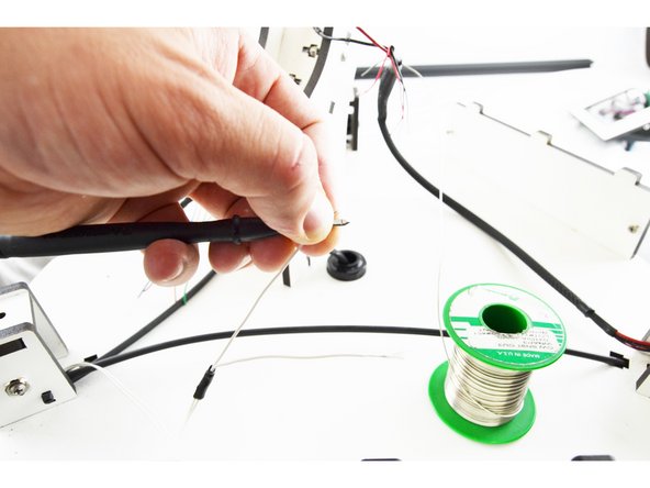 Contact the probe from your multimeter against the metal tab in the latching housing as shown in the picture with the blue arrow.