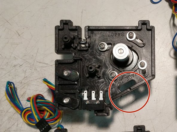You will now route the stepper motor wires in the opposite direction that you routed the end stop wires. Note the arrows on the image for direction. The wires will route through the motor mount plate in the location indicated by a red arrow in the first image.