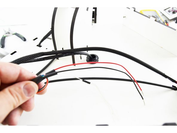 Slide a piece of heat-shrink tubing over one of the red wires and one of the black wires.