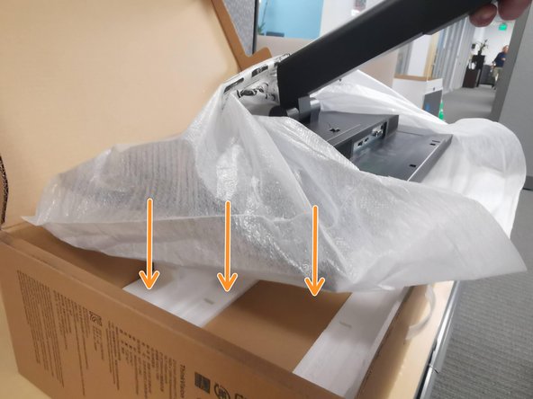 While holding the monitor by the arm: