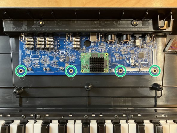 Using the #2 Phillips driver, remove the four Phillips head screws from the main board, as indicated.