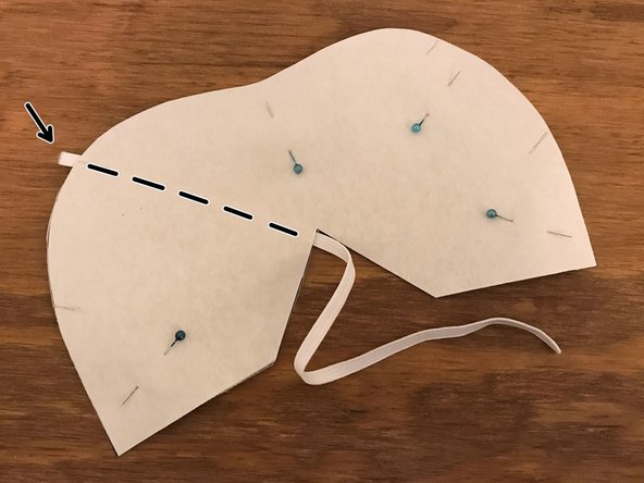 Remove an existing pin if necessary to make room, and place one of the 12&quot; (30 cm) elastic straps between the two layers of cotton fabric.